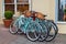 Four blue bicycles with baskets.