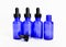 Four blue glass eyedropper bottles, one removed