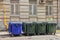 Four blue and green color plastic dumpsters on the city street near building in Moscow