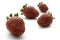 Four bright red strawberries on a white background