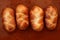 Four brioche pastries over orange clay