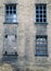 Four broken and bricked up windows in a derelict abandoned house