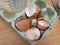 Four broken eggshells in an egg carton