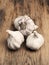 Four bulbs of garlic on a rustic kitchen table