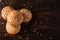 Four buns with seeds on a dark wooden background