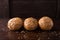 Four buns with seeds on a dark wooden background