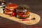 Four burgers on a light wooden board surface. Clouse-up.