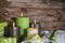 Four burning apple green christmas candles on wooden background.