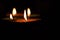 Four burning colorful candles indian style for Diwali celebration on black background. Vertical