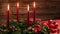 Four burning red candles on a traditional advent wreath with festive decoration