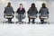 Four business women sitting in office chairs.