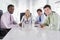 Four businesspeople in a boardroom smiling