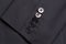 Four buttons on a black business jacket sleeve