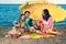 Four carefree friends seated under yellow umbrella.