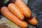 four carrots on a wooden placemat