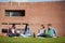 Four casual students sitting on the grass chatting