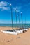 Four catamarans laid on the sand by the sea