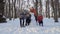 Four ccaucasian boys posing for camera with snowman in winter park