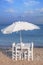 Four chair and umbrella with wooden table on beach and blue sea