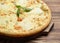 Four cheese pizza quattro fromaggi with basil leaf on a rustic w