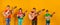 Four children with acoustic guitars in bright and colorful clothes stand in a row on a yellow background