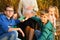 Four children are looking into the camera, small children are sitting next to a pregnant woman and holding their hands on their