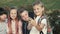 Four children are sitting on a bench and trying to make selfie.