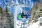 Four children on ski chairlift in the snowy forest