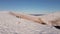 Four climbers walk on the ridge of a snowy mountain. People conquer the tops of winter mountains. Aerial view.