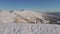 Four climbers walk on the ridge of a snowy mountain. People conquer the tops of winter mountains. Aerial view.