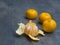 four close up tangerine mandarin orange one peeled on defocused