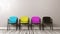 Four CMYK Colored Chairs on Wooden Floor