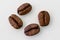 Four coffee beans on a white background