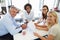 Four colleagues meeting around a table in an office