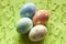 Four colored Easter eggs on green background