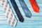 Four colored ties in row on wooden blue background