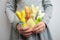 Four colorful bright handmade Easter bunnies in the hands of a little girl in gray clothes