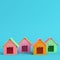 Four colorful doghouses on bright blue background in pastel colors