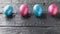 Four colorful eggs on a dark rustic table. The decoration of the Easter table.