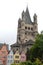 Four colorful houses and a large tower in the center of Cologne in Germany