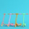 Four colorful kick scooters on bright blue background in pastel colors. Minimalism concept