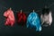 Four colorful wigs hanging on rope isolated