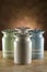 Four colourful ceramic canisters on timber bench with rustic background