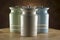 Four colourful ceramic canisters on timber bench with rustic background