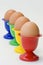 Four colourful egg holders in row