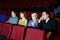 Four concentrated people watch movie in movie theater