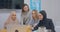 Four confident cheerful diverse colleagues office women hijab discussion business plan use laptop laughter joy