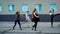 Four contemporary dancers is rehearsing modern dance on a street in front of building in daytime