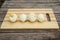 Four cooked and peeled chicken eggs lie on a cutting board on a wooden background. You can see the yolks. The protein is damaged.