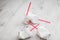 Four crumpled white paper cups with red tubes for coffee to go on white wooden table in selective focus